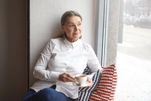 happy old woman sitting while drinking coffee (1)